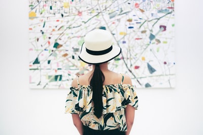 The woman standing in front of abstract painting
